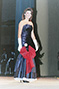 Pic of brunette in blue dress, red bow